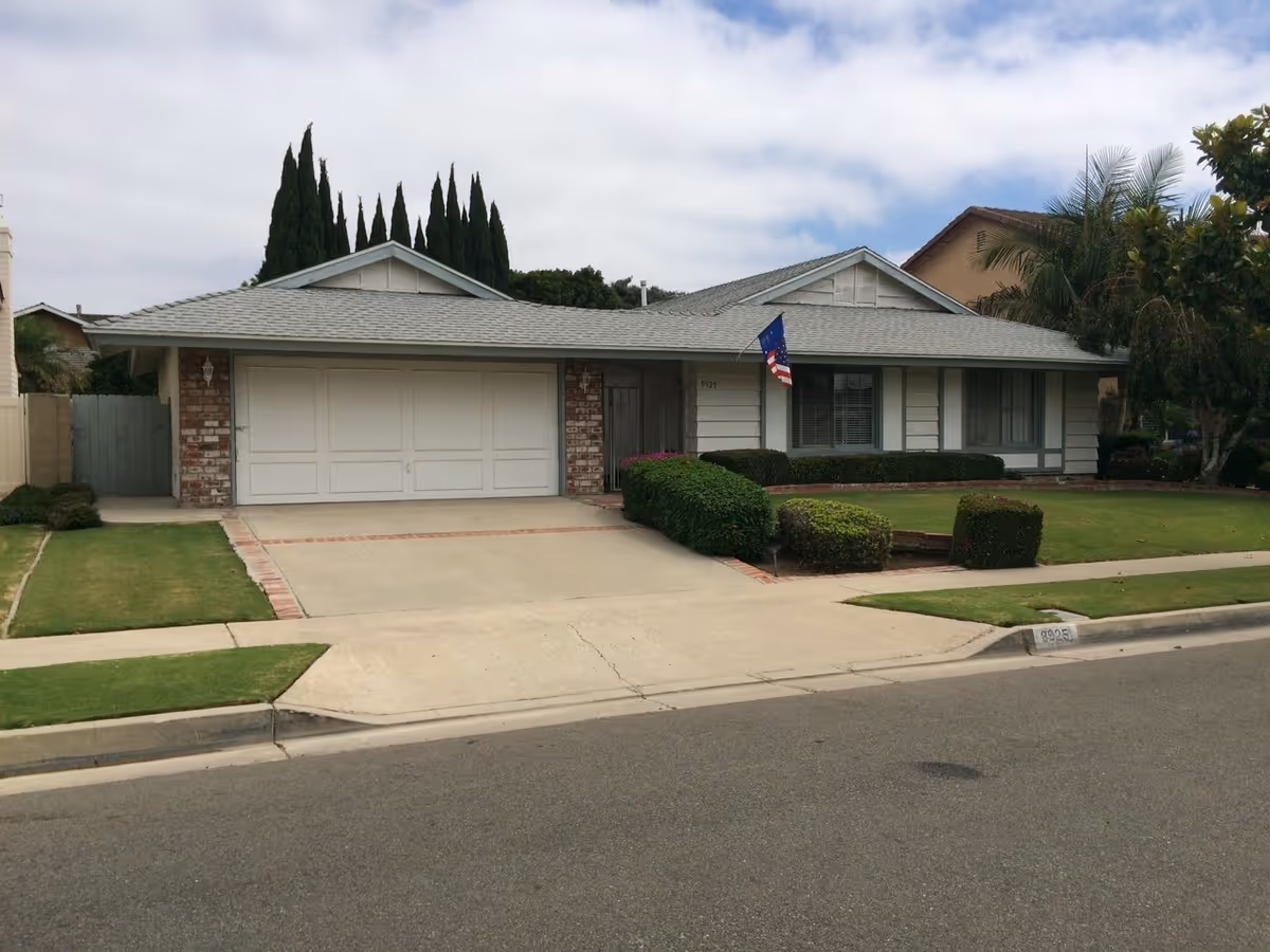 Single-story suburban house with a two-car garage and manicured front lawn.