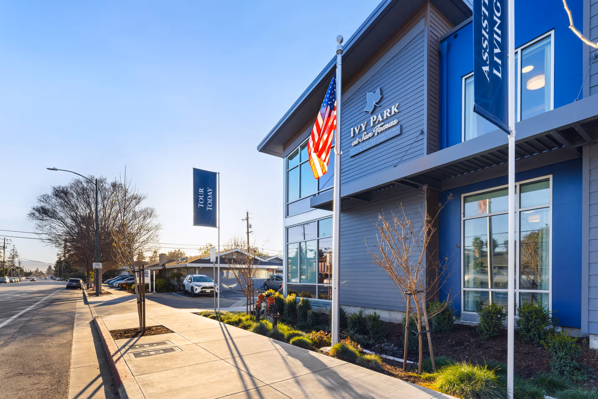 Exterior view of Ivy Park at San Tomas facility with flags and sidewalk.
