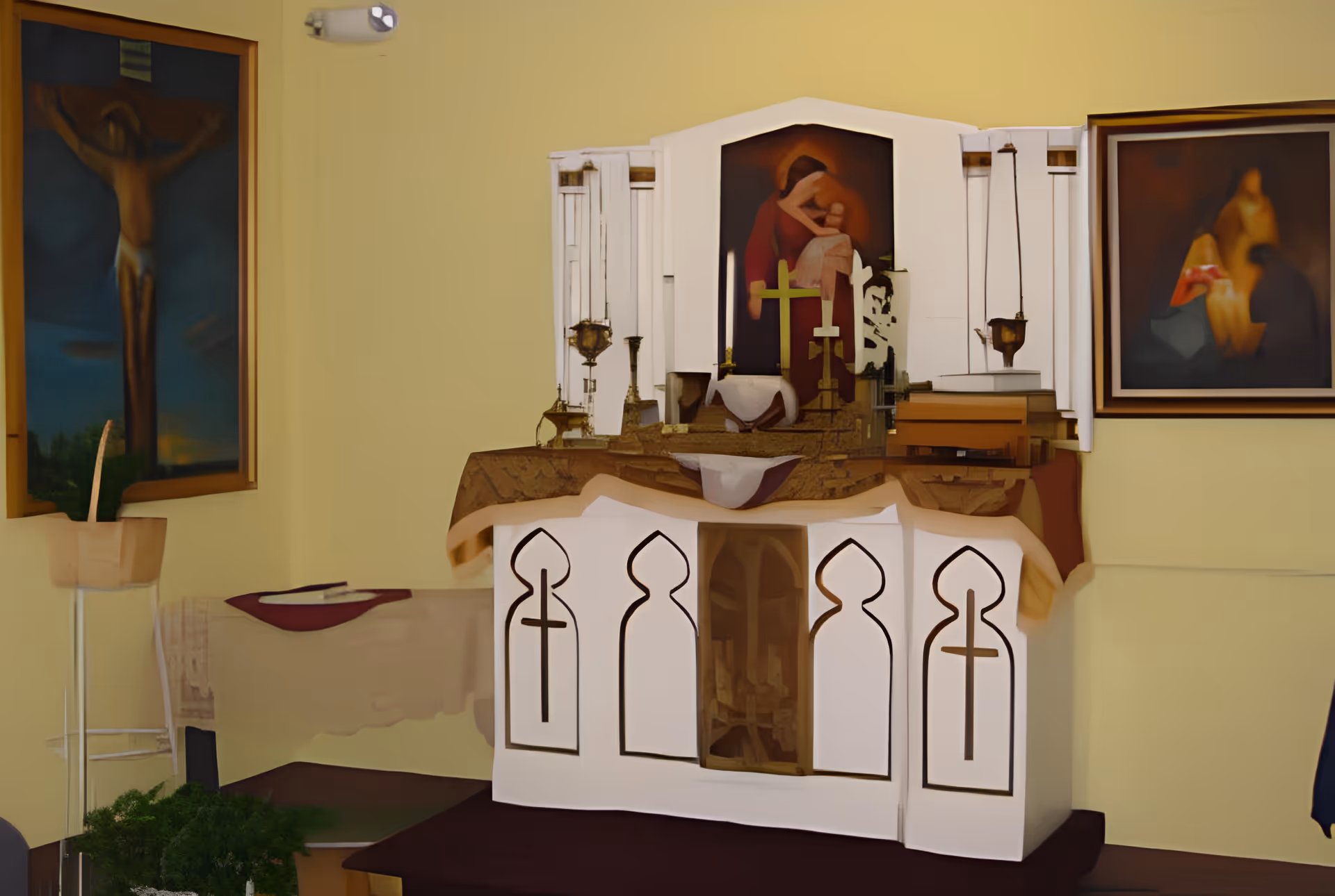 Small chapel-style interior with an altar decorated with crosses, candles, and religious paintings on the walls.