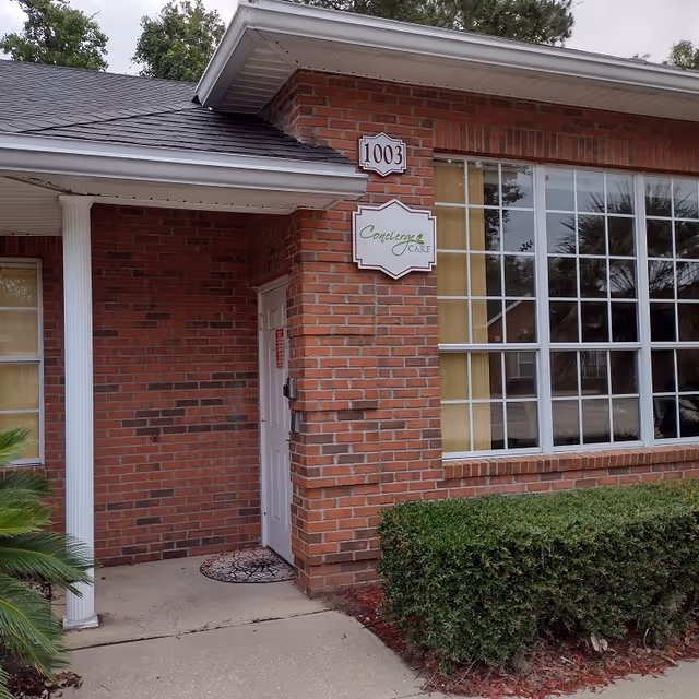 Brick building entrance with Concierge Care sign and large front windows.