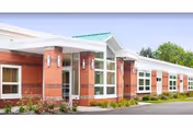 Exterior view of a red brick senior living center with white trim.