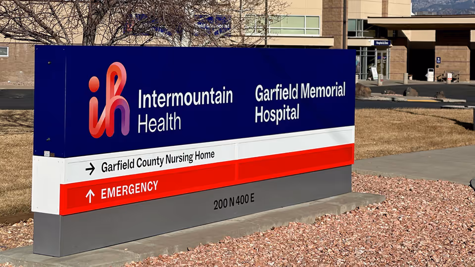 Outdoor sign for Garfield Memorial Hospital and Garfield County Nursing Home near a building