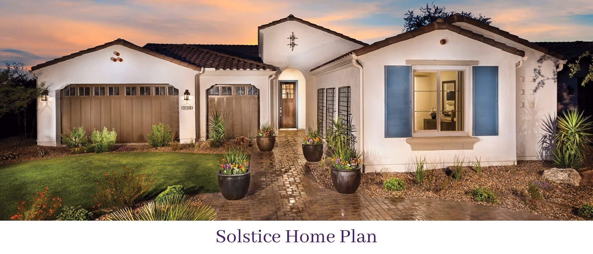 Front exterior of a single-story Mediterranean-style home with a garage, potted plants, and a paved walkway at sunset.