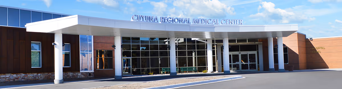 Main entrance of Cuyuna Regional Medical Center with a covered drop-off, white columns and a large glass facade.