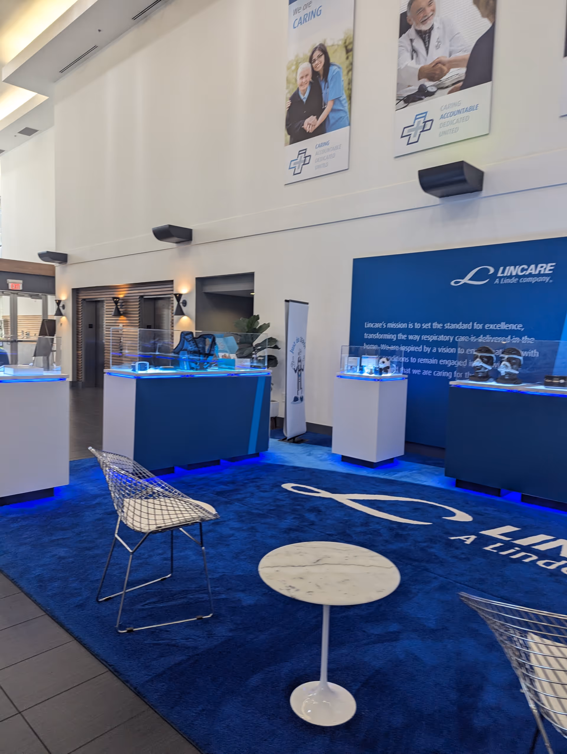Interior lobby with blue carpet, glass display counters, and modern seating.