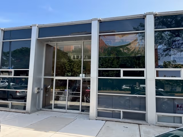 Glass-fronted senior care facility entrance with double doors and sidewalk.
