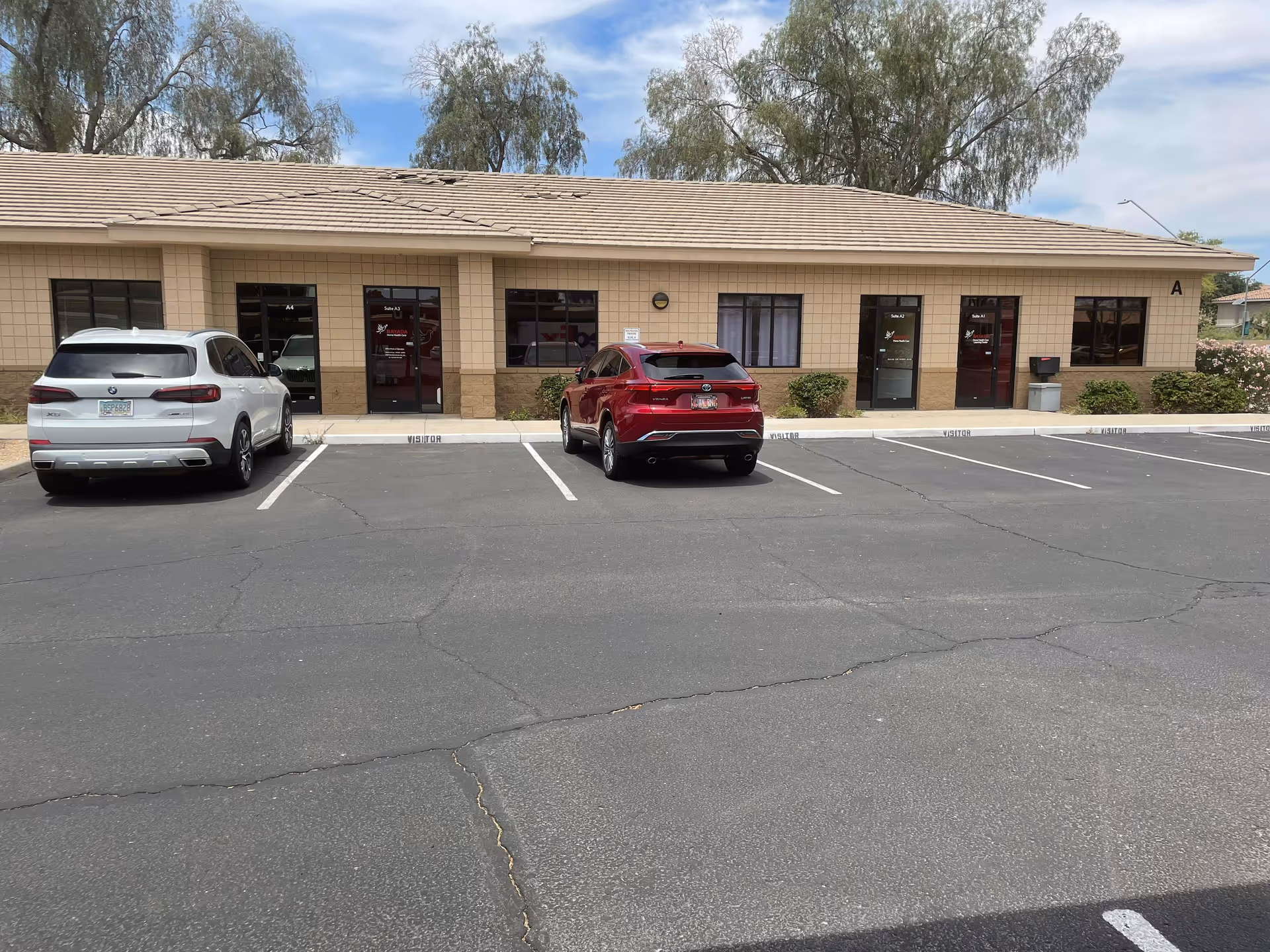 Front view of BAYADA Home Health building with parked cars in a lot