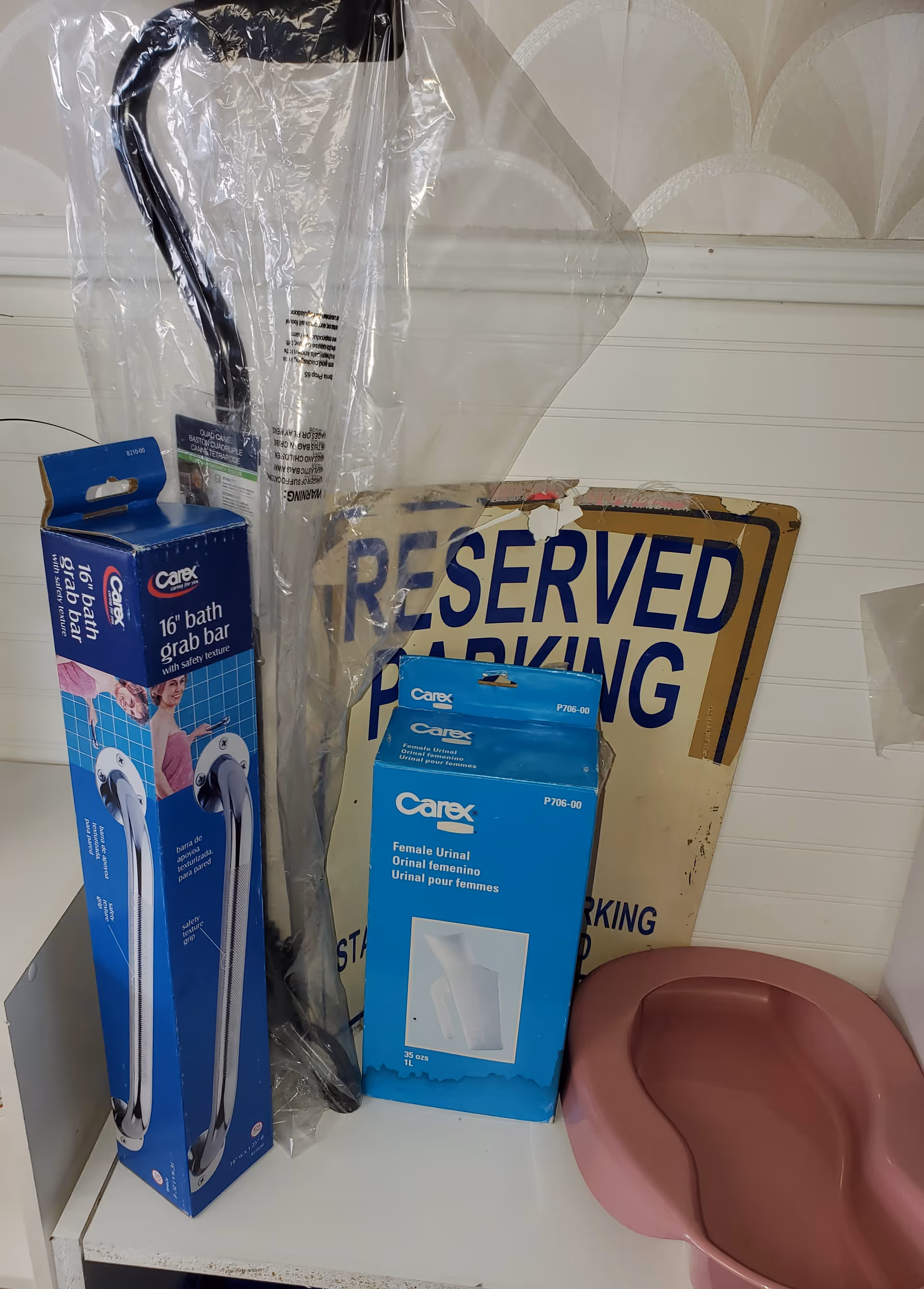 Interior storage area with blue Carex medical supply boxes, plastic-covered display, and a reserved parking sign.
