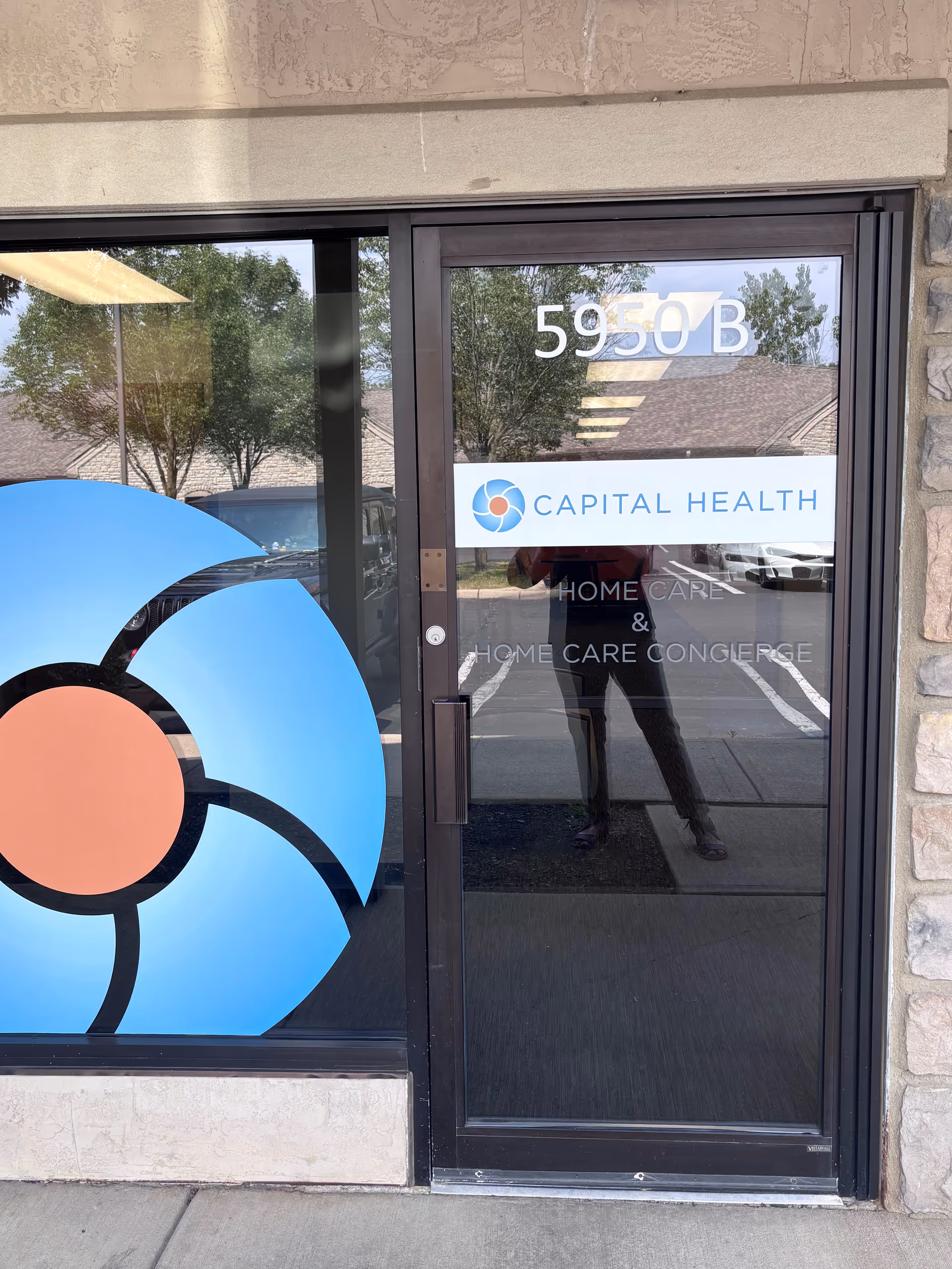 Glass door entrance with Capital Health sign and a large blue logo.