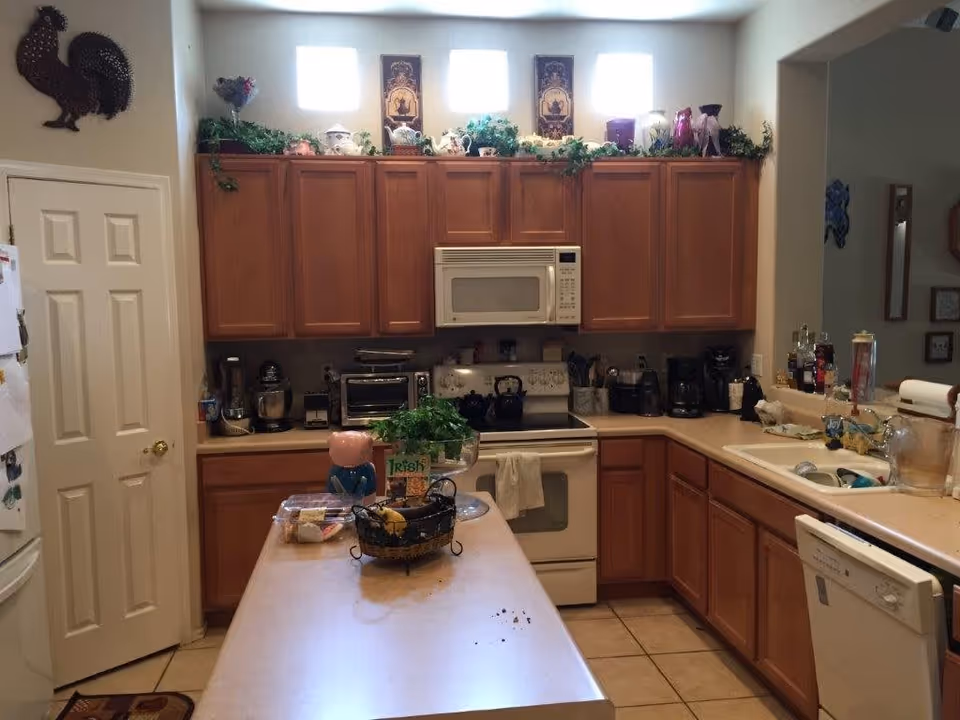 A spacious kitchen featuring wooden cabinets, various appliances, and decorative items.