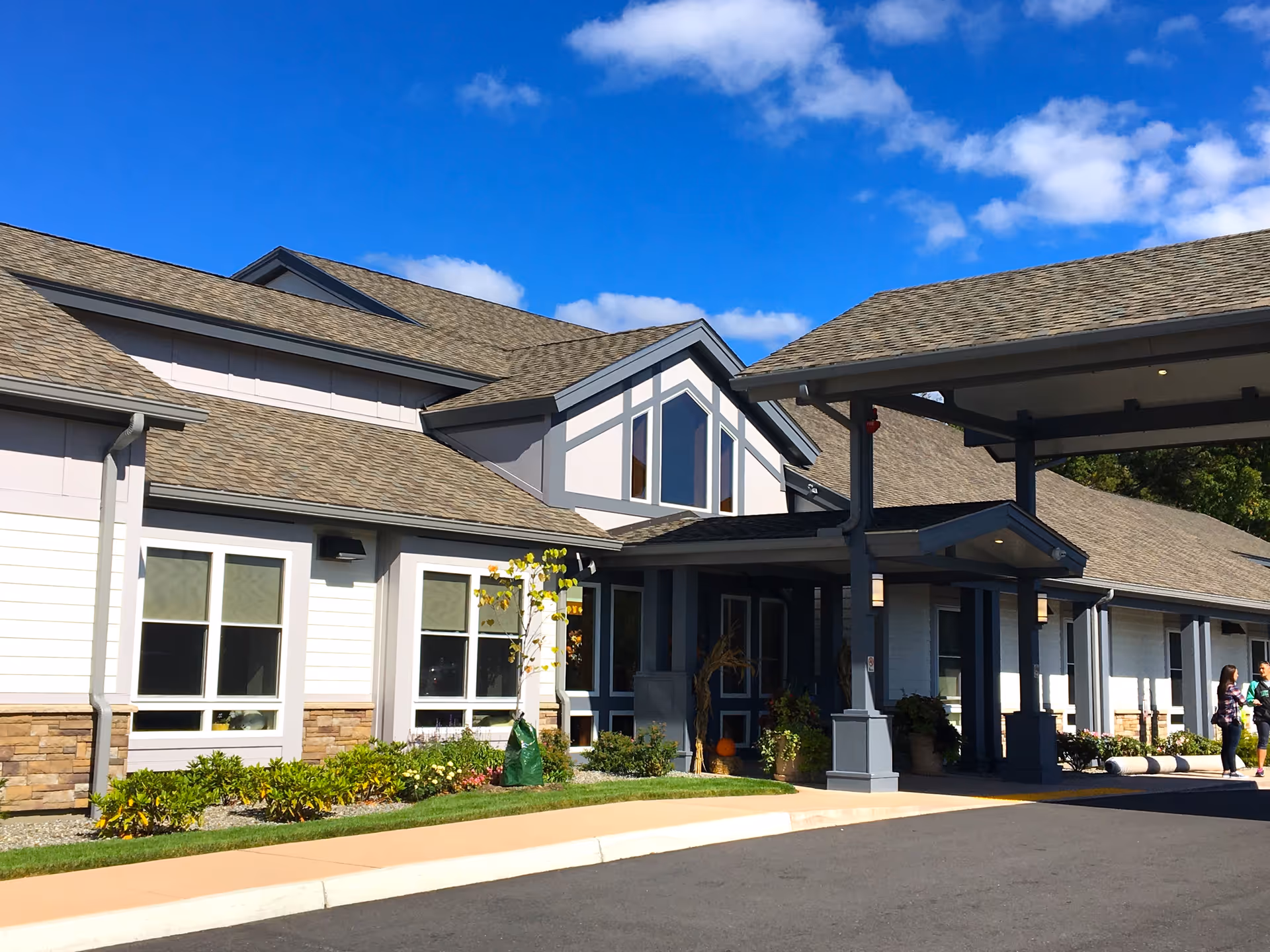 Oasis at Dodge Park exterior: modern building with a covered entrance and landscaped front yard.