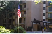 Exterior view of Victory Forest senior living building with flagpole and entrance