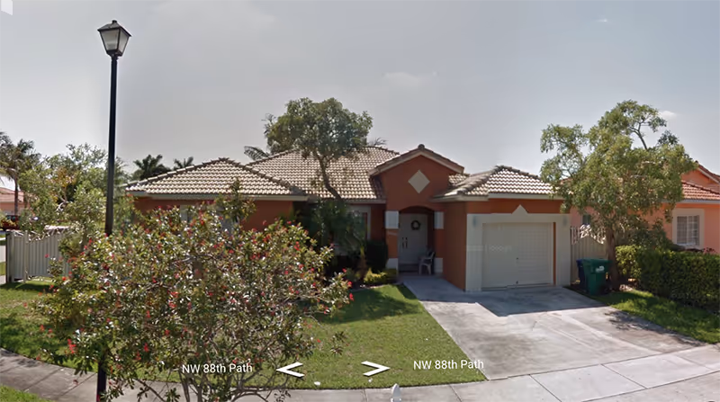 Single-story orange retirement home with tiled roof, front yard, and driveway.