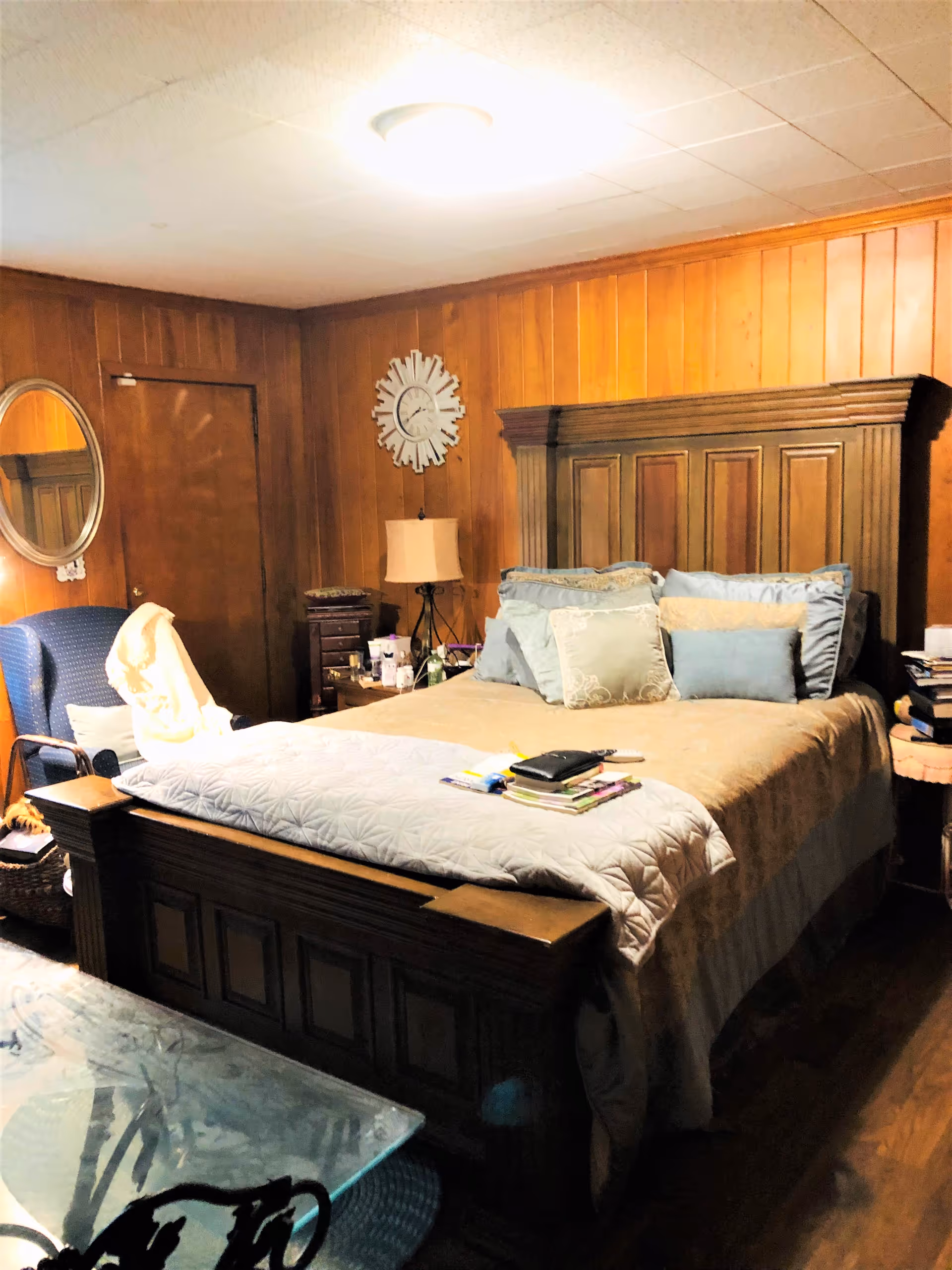 Dark wood bedroom with a large bed, nightstands, and blue pillows.