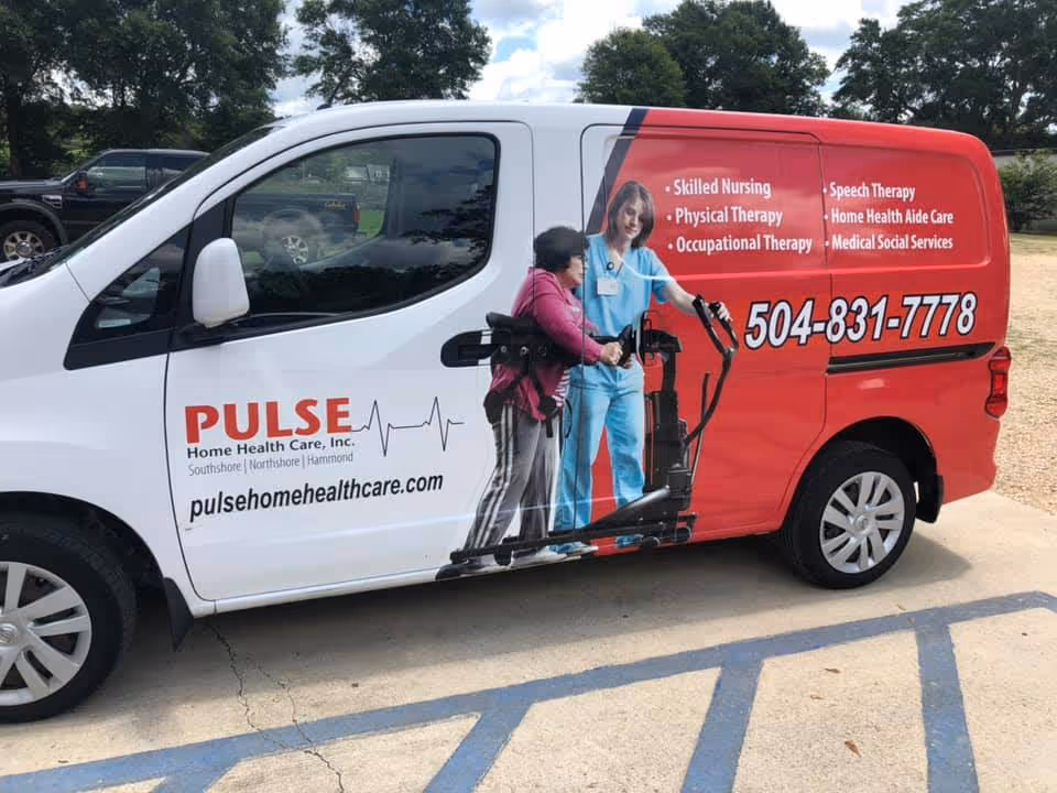 Pulse Home Health Care van with red artwork and a caregiver figure outside parking area.