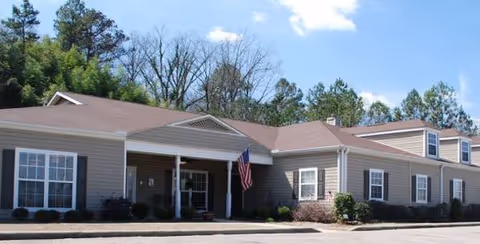 Exterior front view of Gardens of Pelham with entrance and flag
