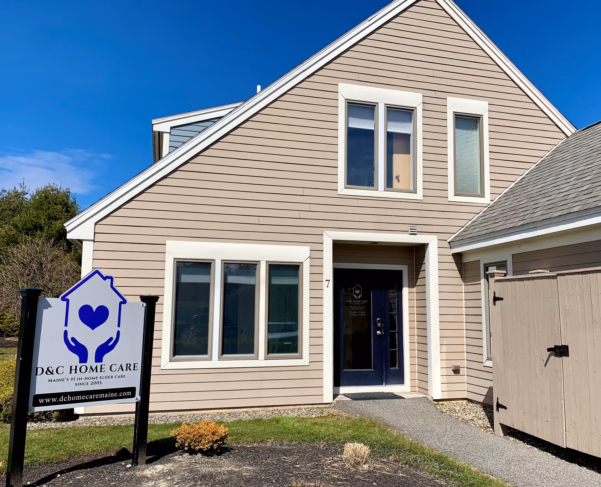 Front exterior of a beige, gable-roof building with a D&C Home Care sign