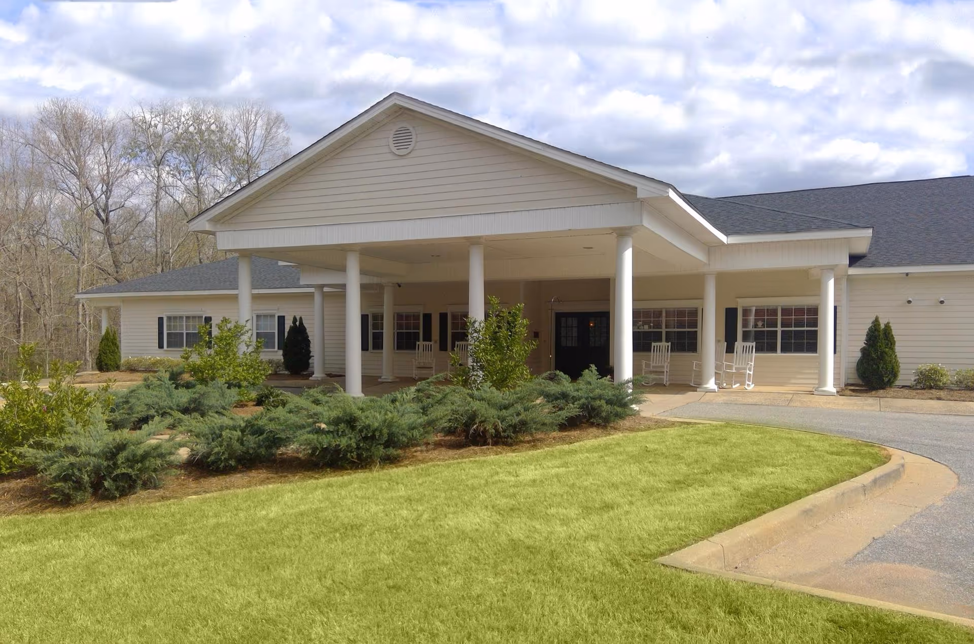 Single-story senior living facility with a covered front entrance and manicured landscaping.