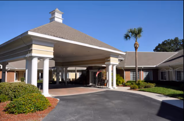 Covered entrance with tall white columns and a driveway leading to the facility.