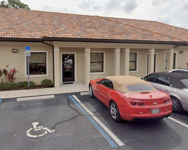 Front entrance of a Senior Helpers facility with a red convertible parked in a handicap spot.