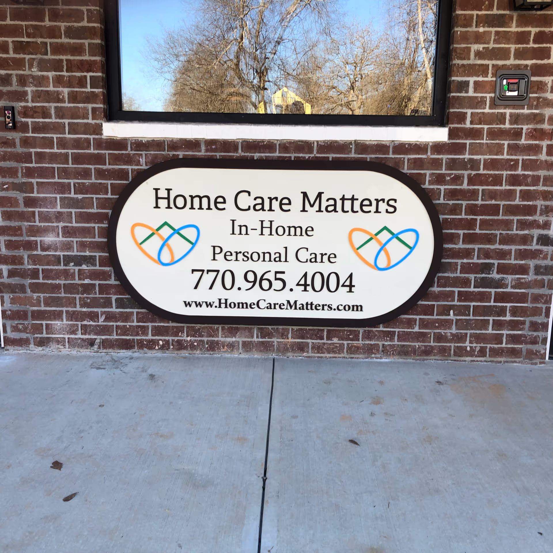 Oval sign on brick wall reading Home Care Matters In-Home Personal Care