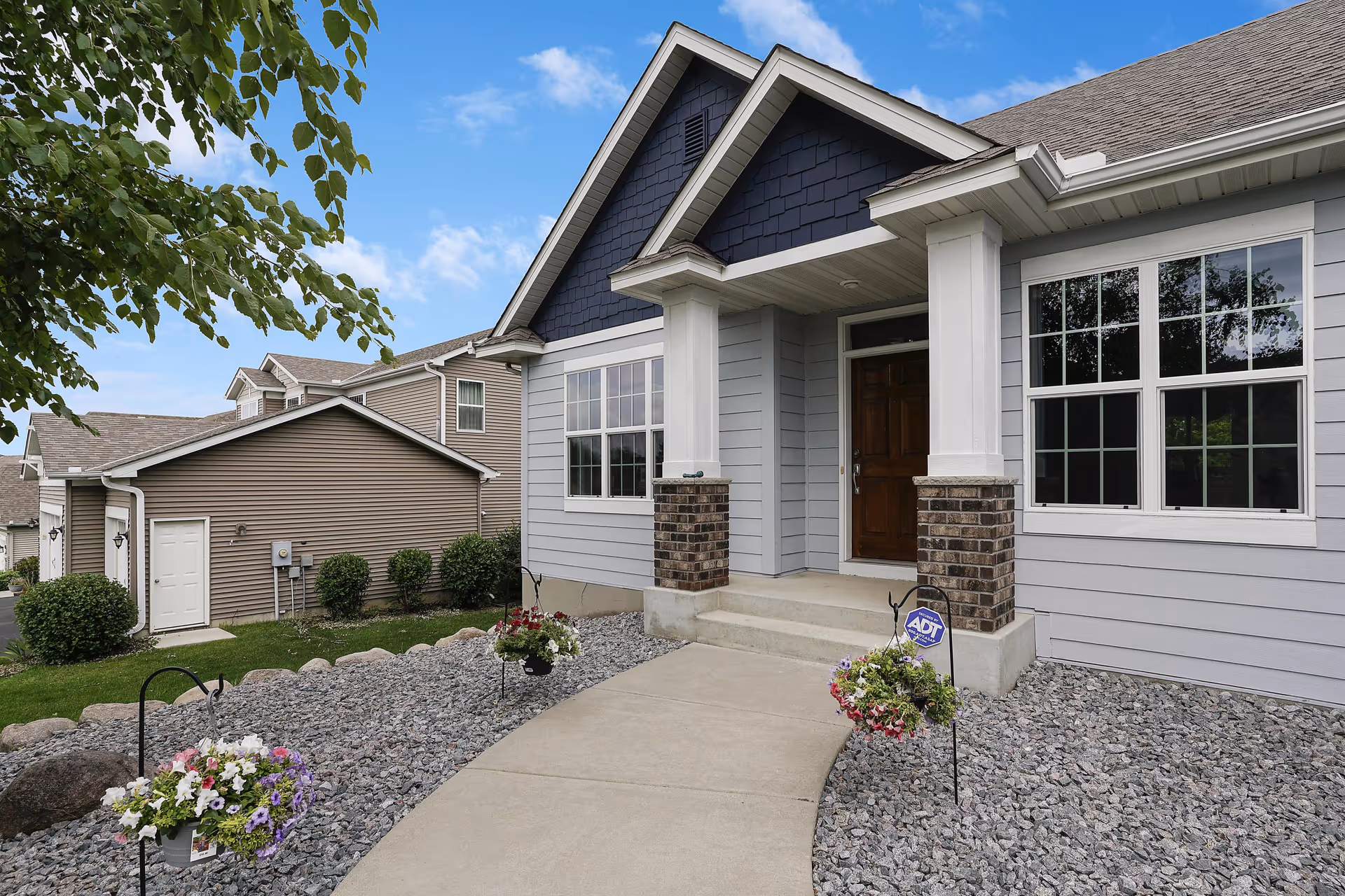 Front exterior of a modern assisted living facility with a welcoming entrance and landscaped walkway.