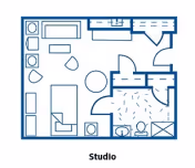 Floor plan of a studio apartment showing a combined living and sleeping area with a bed, sofa, table, and chairs, a kitchenette, and a bathroom with a toilet and shower.