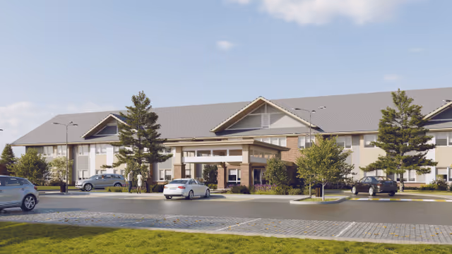 Front exterior view of Ridgeland Senior Living facility showing a two-story building with a covered entrance, several parked cars, trees, and a well-maintained lawn under a partly cloudy sky.