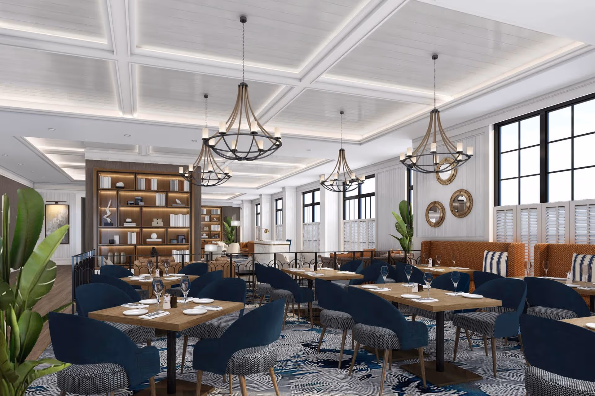 A spacious and elegant dining room with multiple wooden tables set with plates, napkins, and glassware. The room features blue upholstered chairs, large windows with black frames, decorative mirrors on the wall, and modern chandeliers hanging from a white coffered ceiling. There are also plants and a bookshelf in the background.