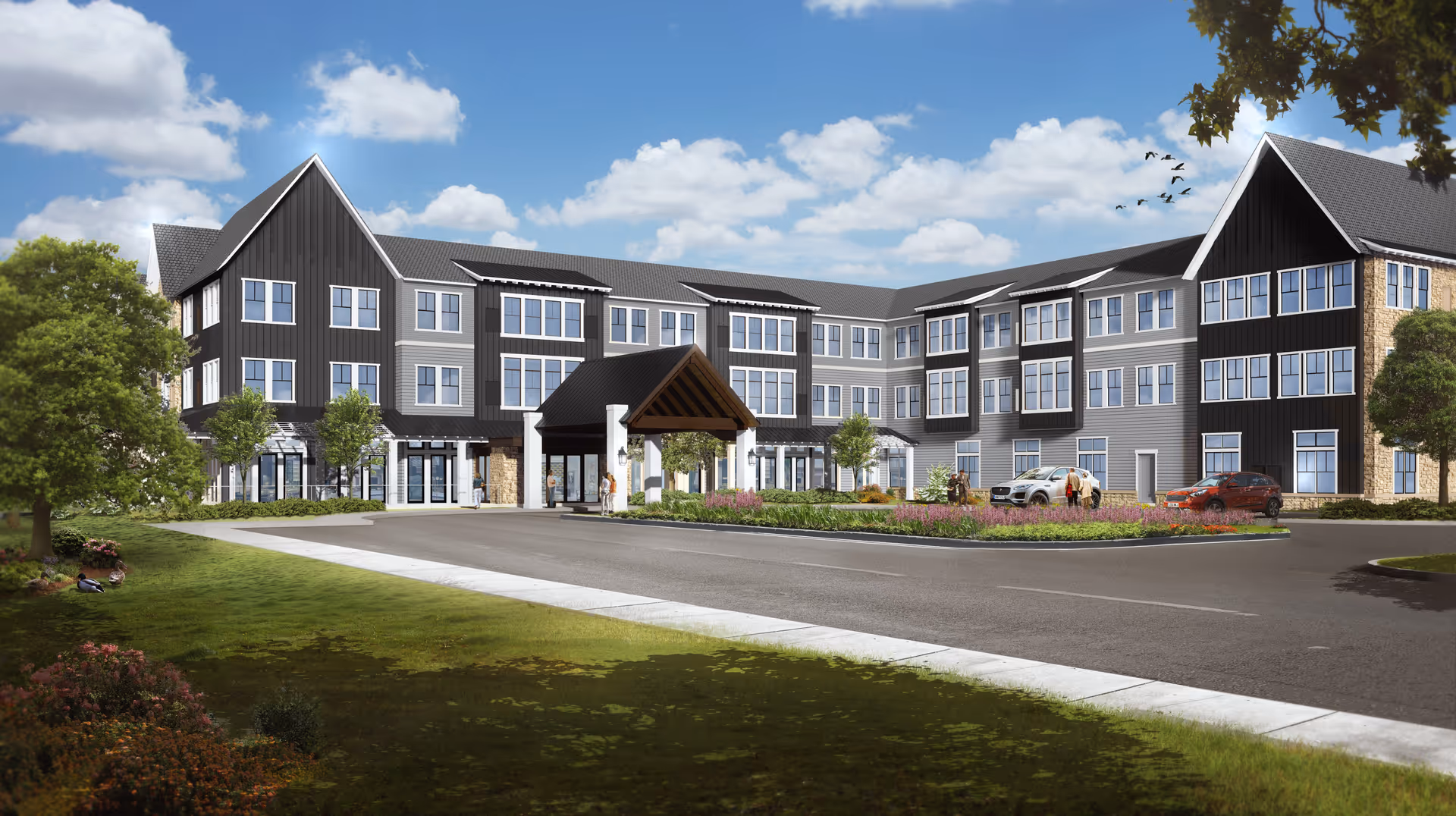Exterior view of a modern three-story senior living facility building with a covered entrance, landscaped garden, parked cars, and a few people near the entrance under a partly cloudy sky.