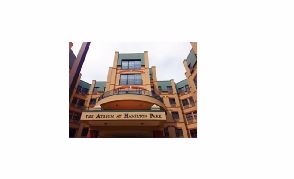 Exterior front view of a multi-story building with a sign that reads 'The Atrium at Hamilton Park' above the entrance.