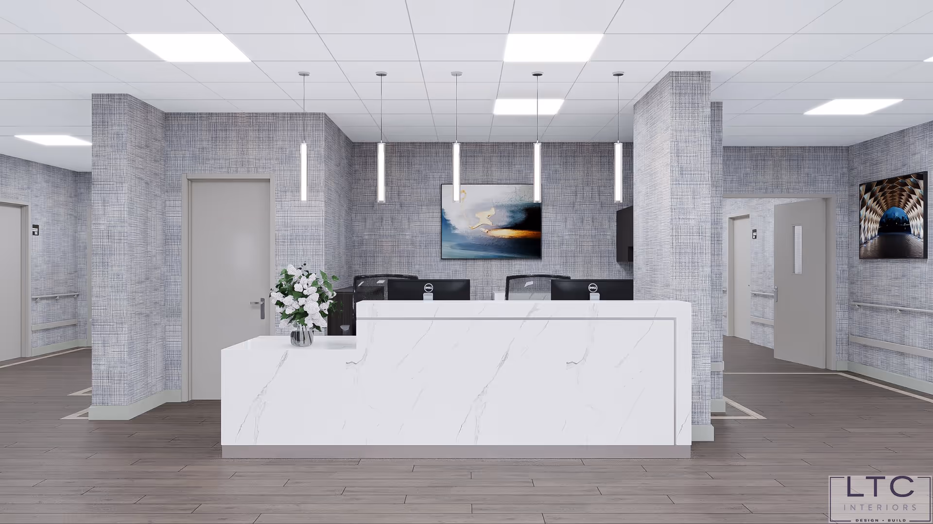 A modern reception area with a white marble front desk, two black office chairs behind the desk, and a vase with white flowers on the left side. The walls have a textured gray pattern, and there are three vertical pendant lights hanging from the ceiling. Two pieces of abstract artwork are mounted on the walls. The floor is a light wood tone, and there are several doors and hallways visible in the background.