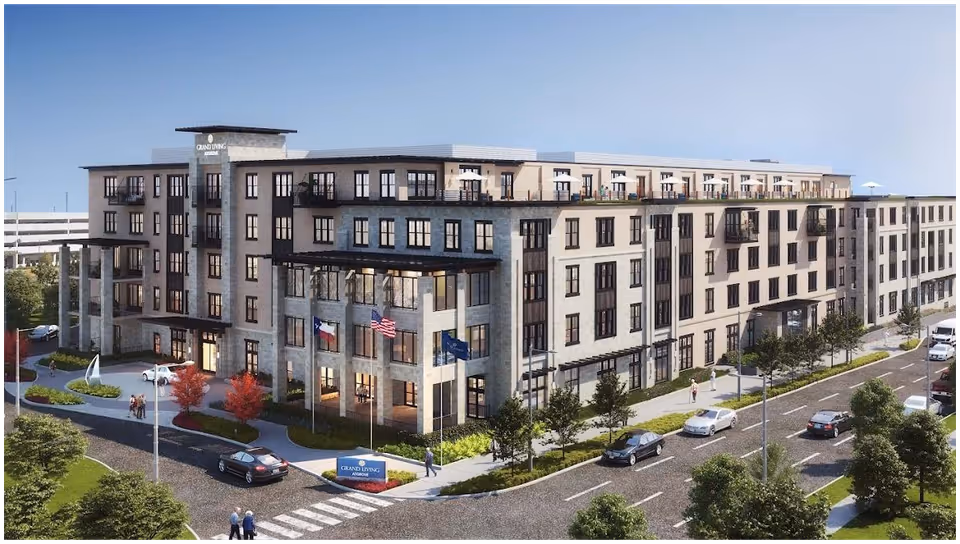 Exterior view of a large, modern senior living facility named Grand Living at The Grove. The multi-story building features numerous windows, balconies, and a landscaped entrance with flags and a sign. Cars and pedestrians are visible on the surrounding streets and sidewalks.