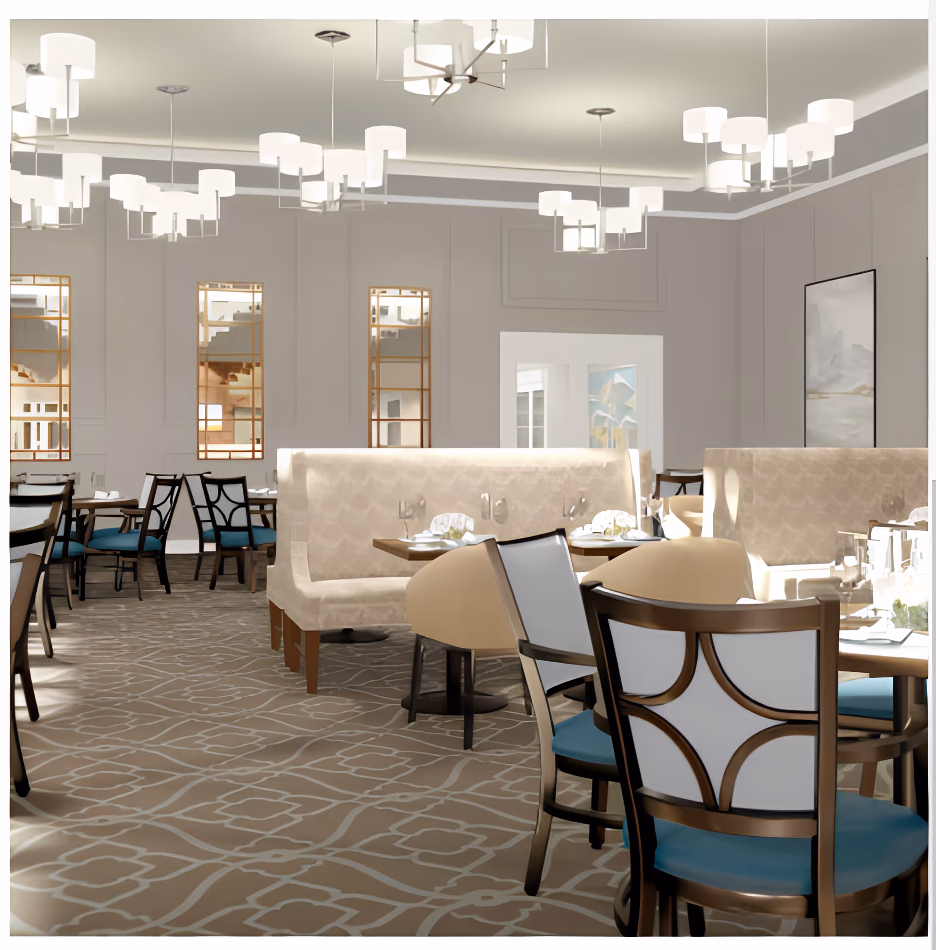 A spacious and elegant dining room with beige upholstered booth seating and wooden chairs with blue cushions. The room features patterned carpet flooring, modern pendant lights hanging from the ceiling, and decorative mirrors on the walls. Tables are set with white plates, napkins, and glassware, creating a welcoming atmosphere.
