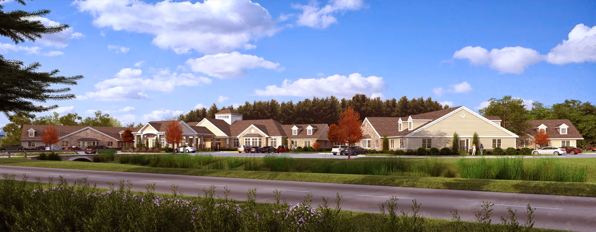 Wide exterior view of Mapleview Country Villa, a large single-story senior living facility with multiple connected buildings, surrounded by trees and landscaping under a partly cloudy blue sky. Several cars are parked in front of the building along a driveway.